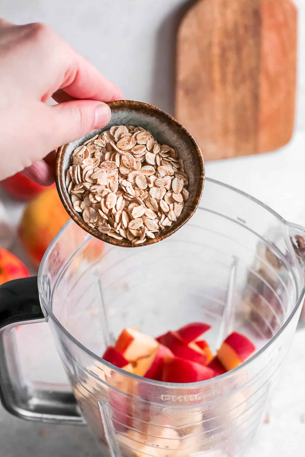 Pouring oats into a blender jar.