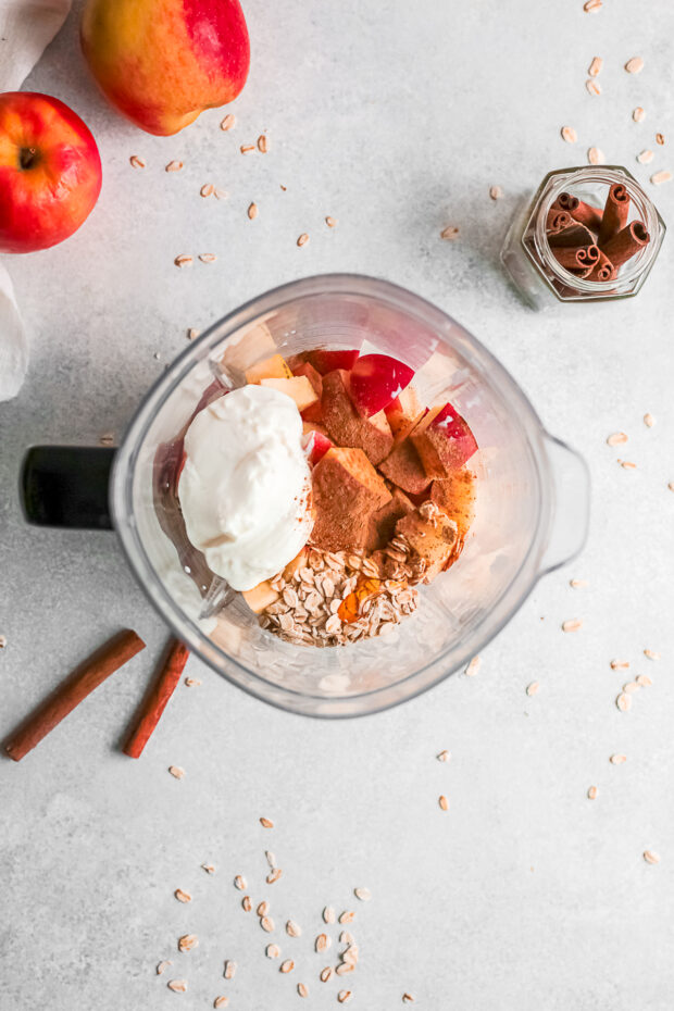Unblended apple pie smoothie ingredients in a blender jar.