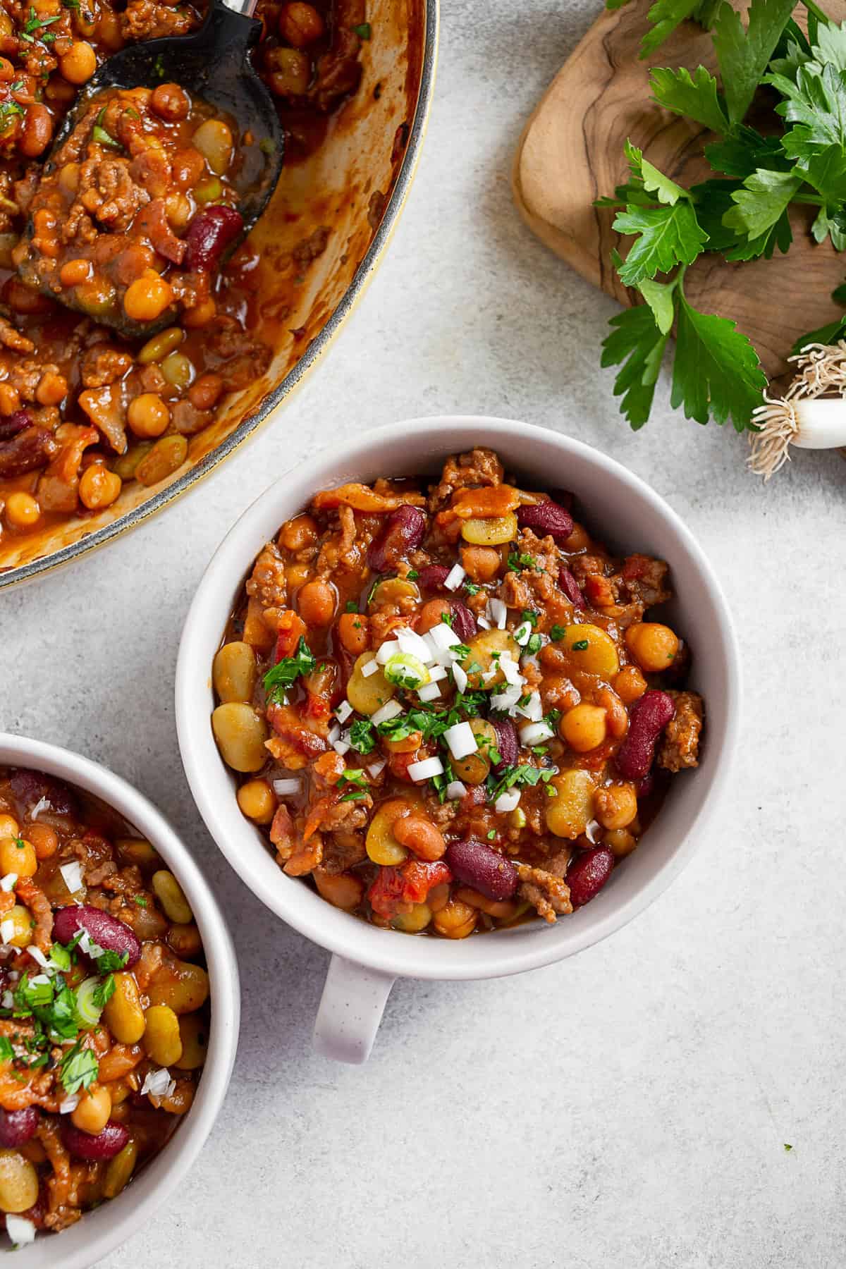 BBQ Calico Beans in a bowl with chopped onions and cilantro on top. 