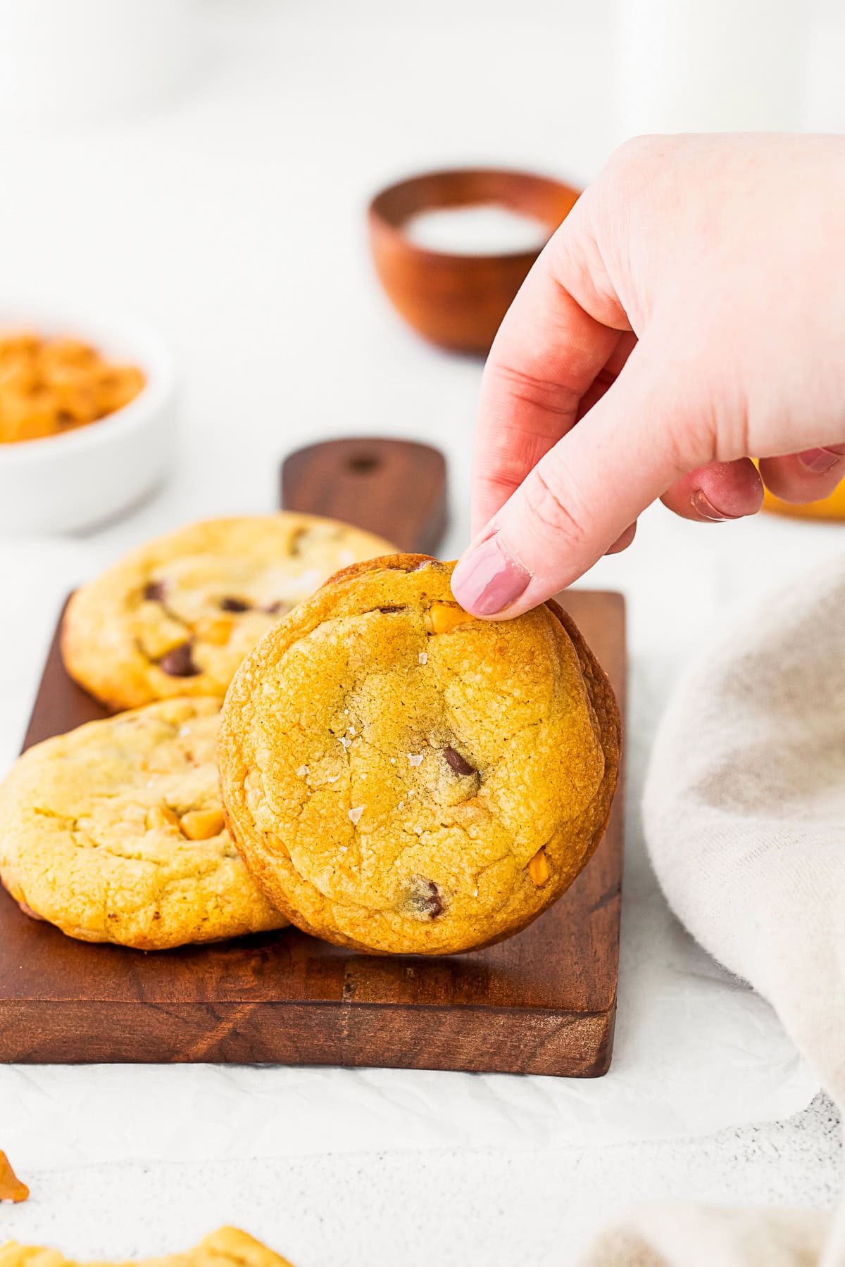 A hand holding at Butterscotch Chocolate Chip Cookie. 