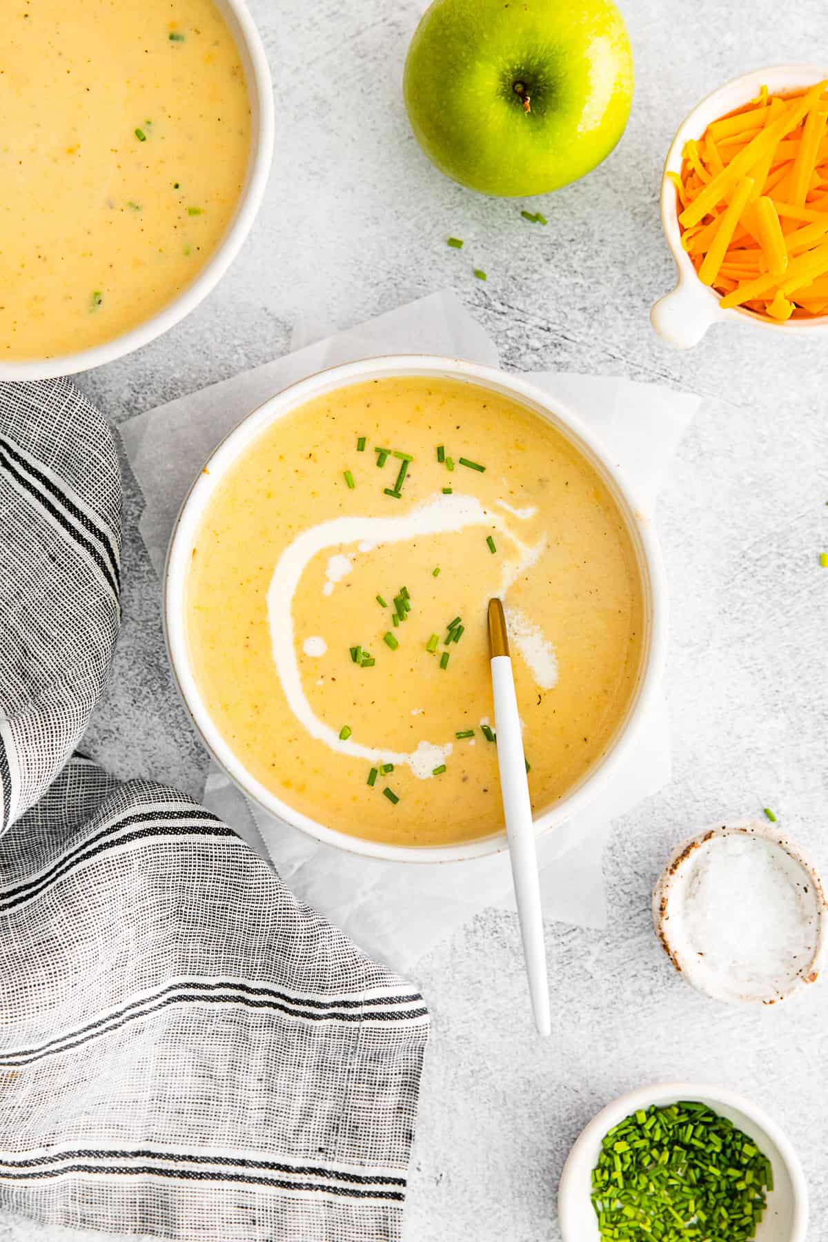 Apple Cheddar Soup in a bowl with a spoon. 