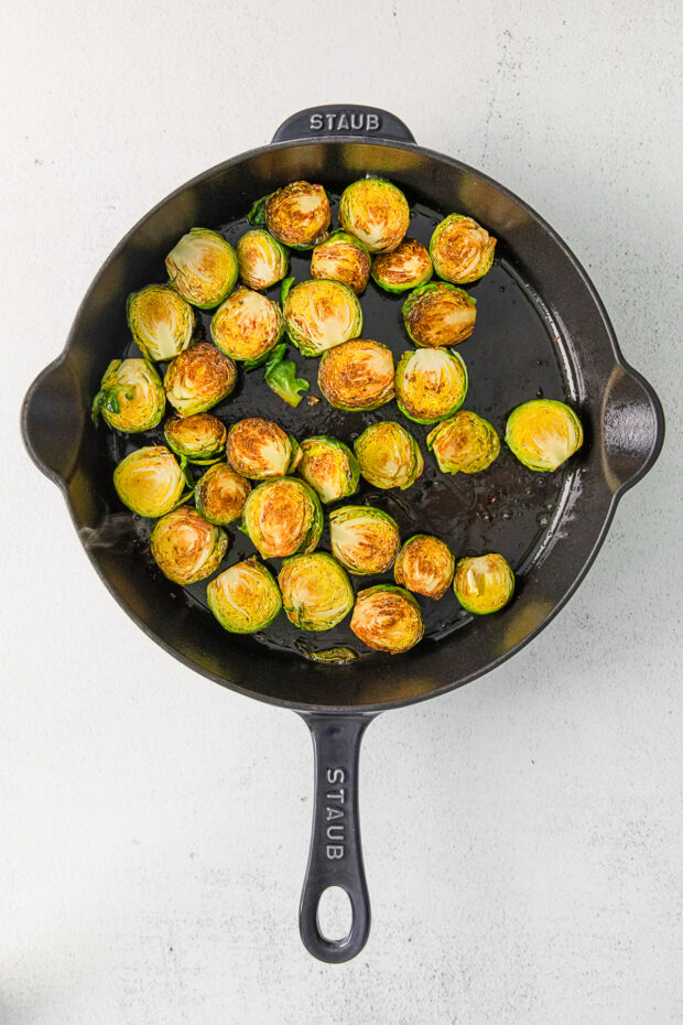 Crispy Brussels sprouts in a cast iron skillet. 