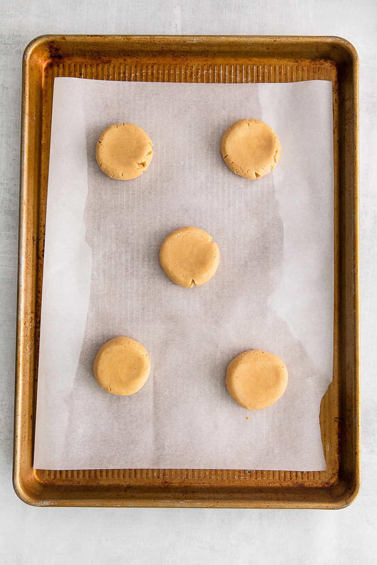 Uncooked maple cookies on a baking sheet pan. 