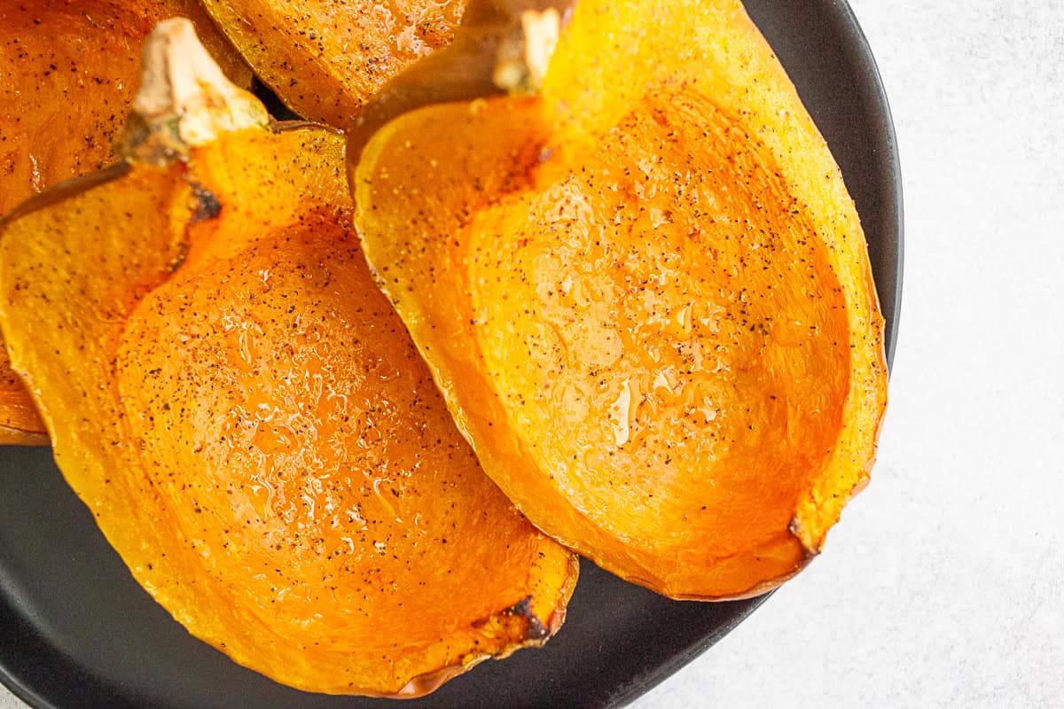 Roasted Koginut Squash on a black plate. 