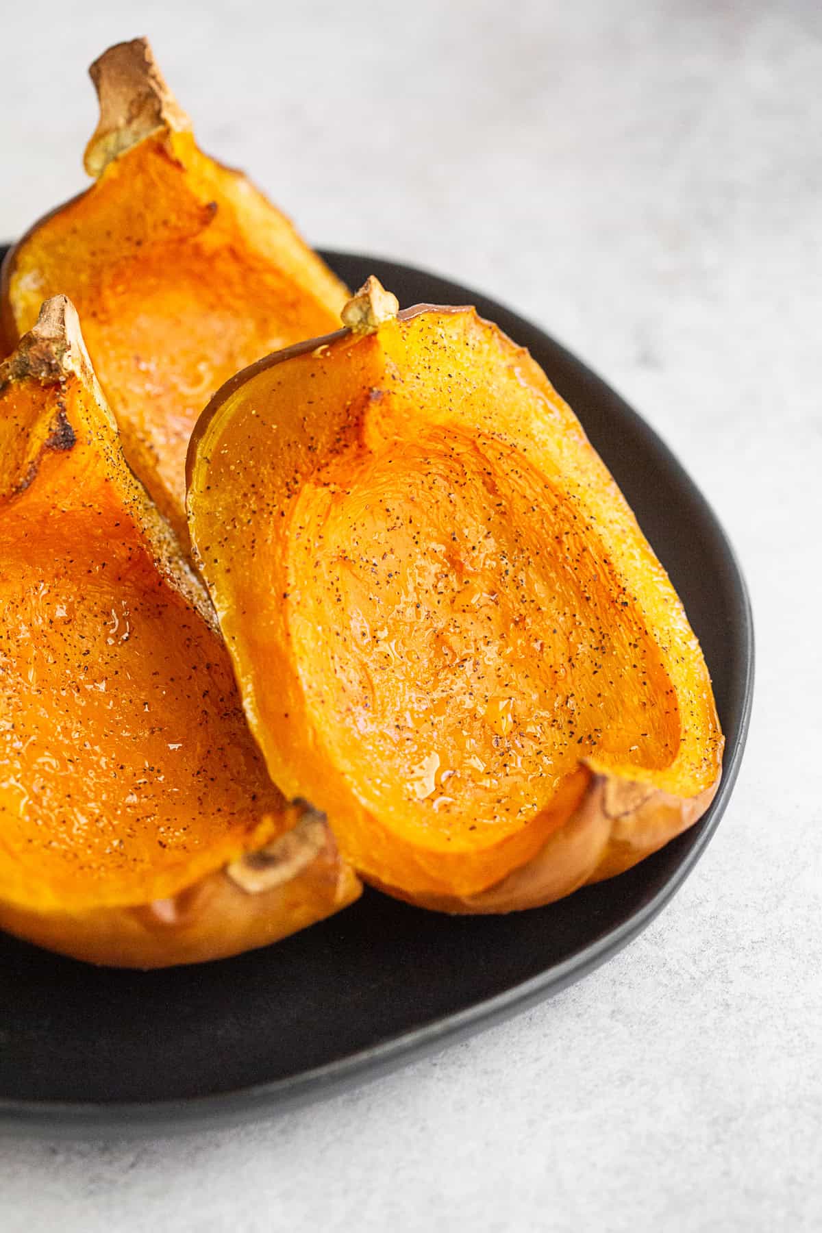Roasted Koginut Squash seasoned with kosher salt and pepper on a plate. 