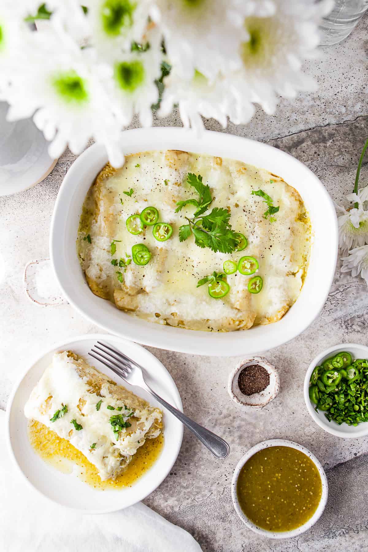 Salsa Verde Chicken Enchiladas in a casserole dish and on a plate. 