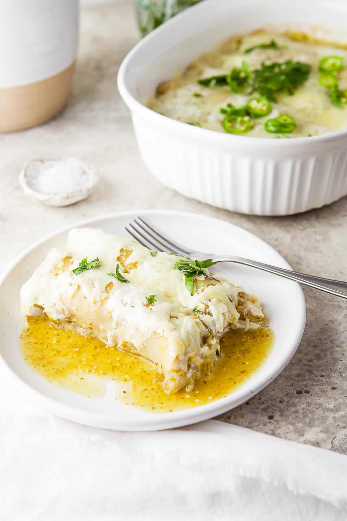 Salsa Verde Chicken Enchiladas served on a plate with a fork. 