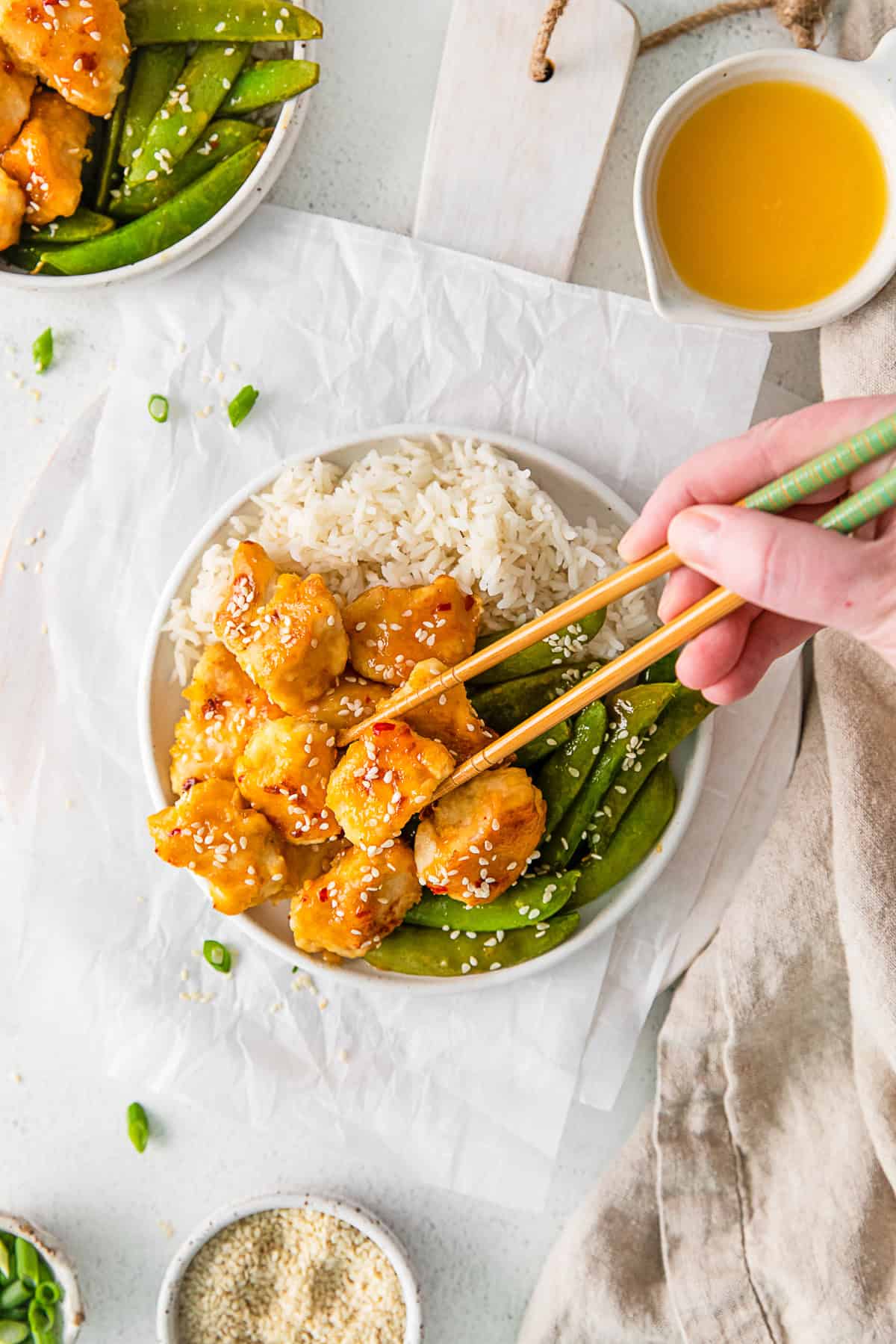 Sheet Pan Orange Chicken on a plate with chopsticks. 