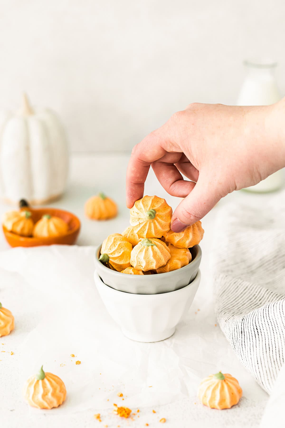 A hand grabbing some Pumpkin Spice Meringue Cookies.