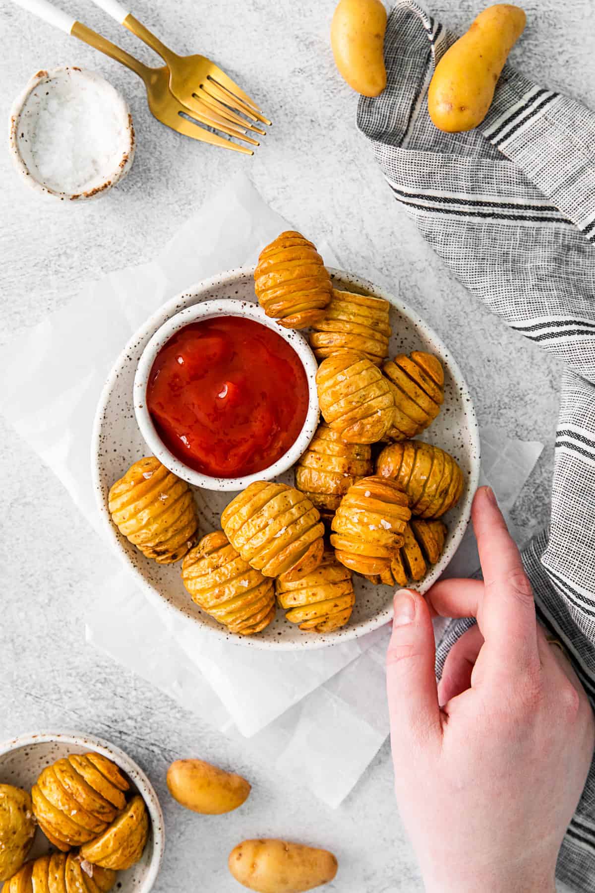 Air Fryer Hasselback Potatoes on a plate with ketchup and kosher salt.
