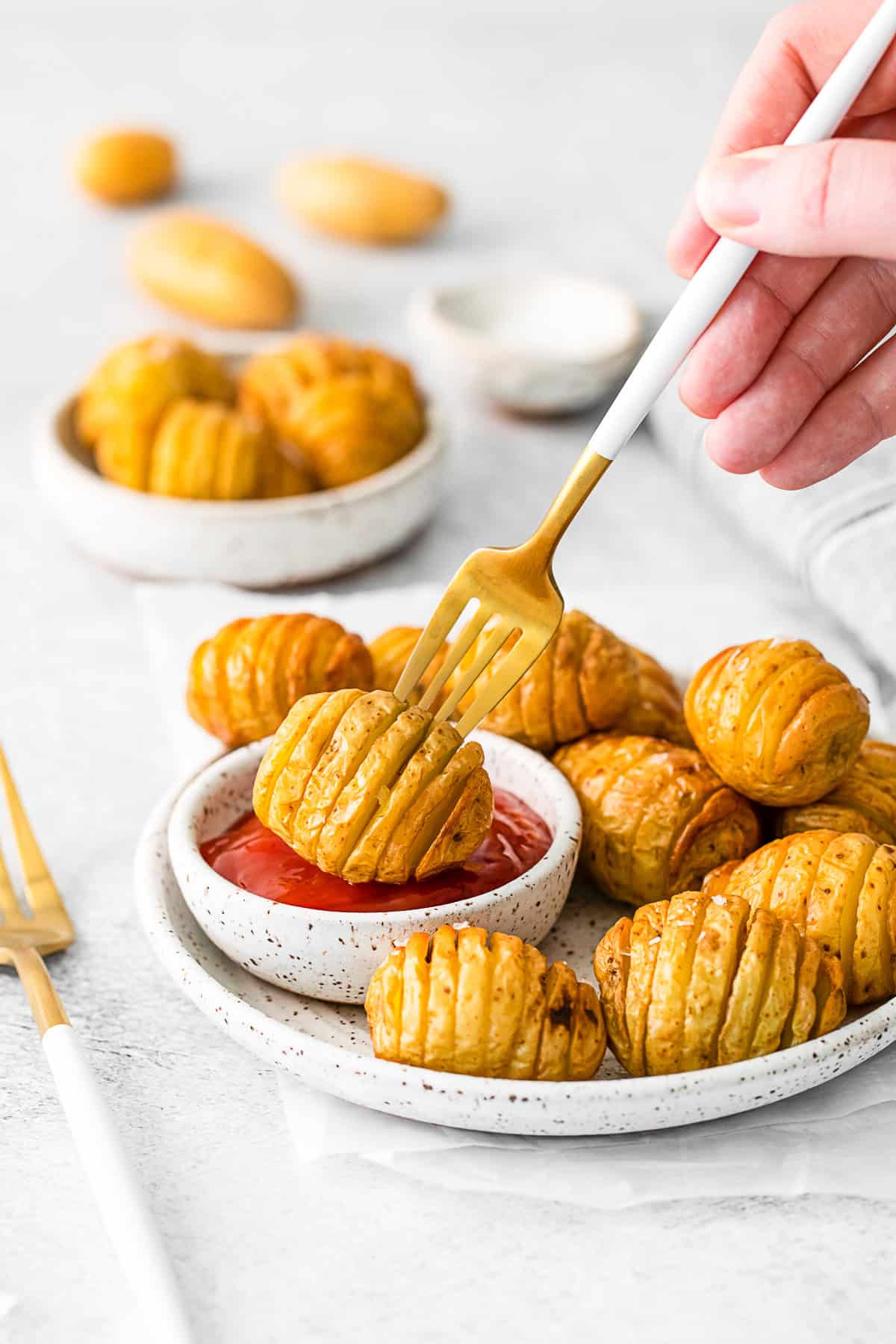 Air Fryer Hasselback Potatoes on a plate with a fork picking it up.