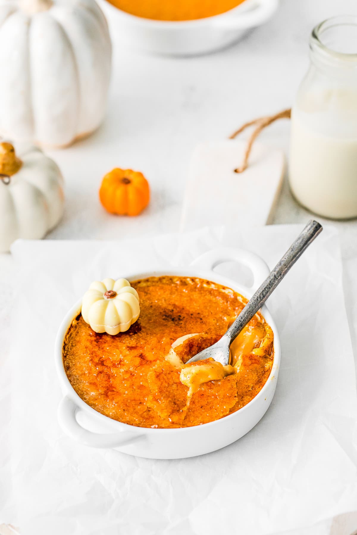 A spoon cracking the sugar topping on a Pumpkin Creme Brulee. 