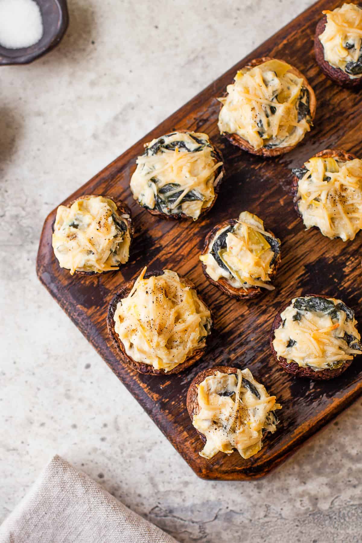 Spinach Artichoke Stuffed Mushrooms topped with Parmesan cheese.