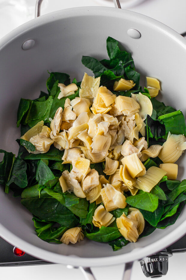 Spinach and artichokes in a pan.