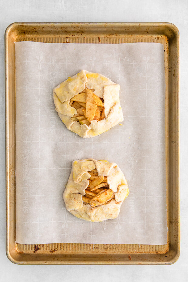 Uncooked Apple Galettes on a sheet pan. 