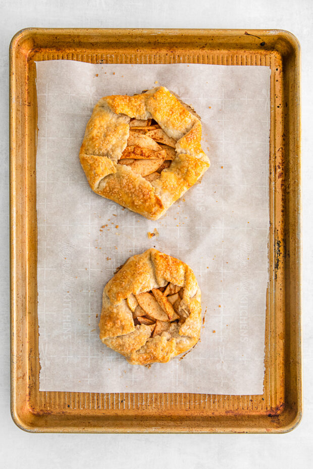 Cooked apple galettes on a sheet pan. 
