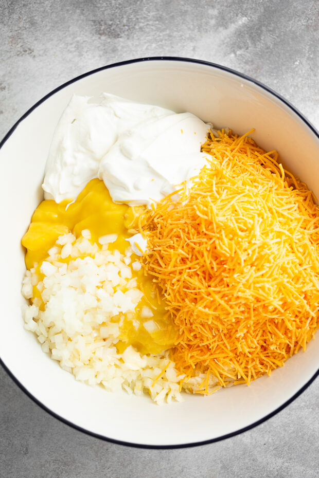 Raw ingredients to make hash brown casserole in a bowl. 