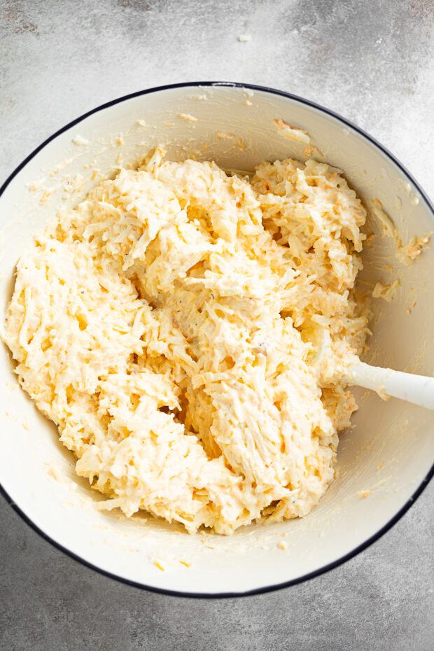 Cheesy Potatoes (Funeral Potatoes) mixed together in a bowl. 