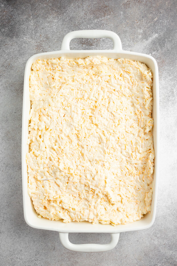 Uncooked funeral potatoes in a dish. 