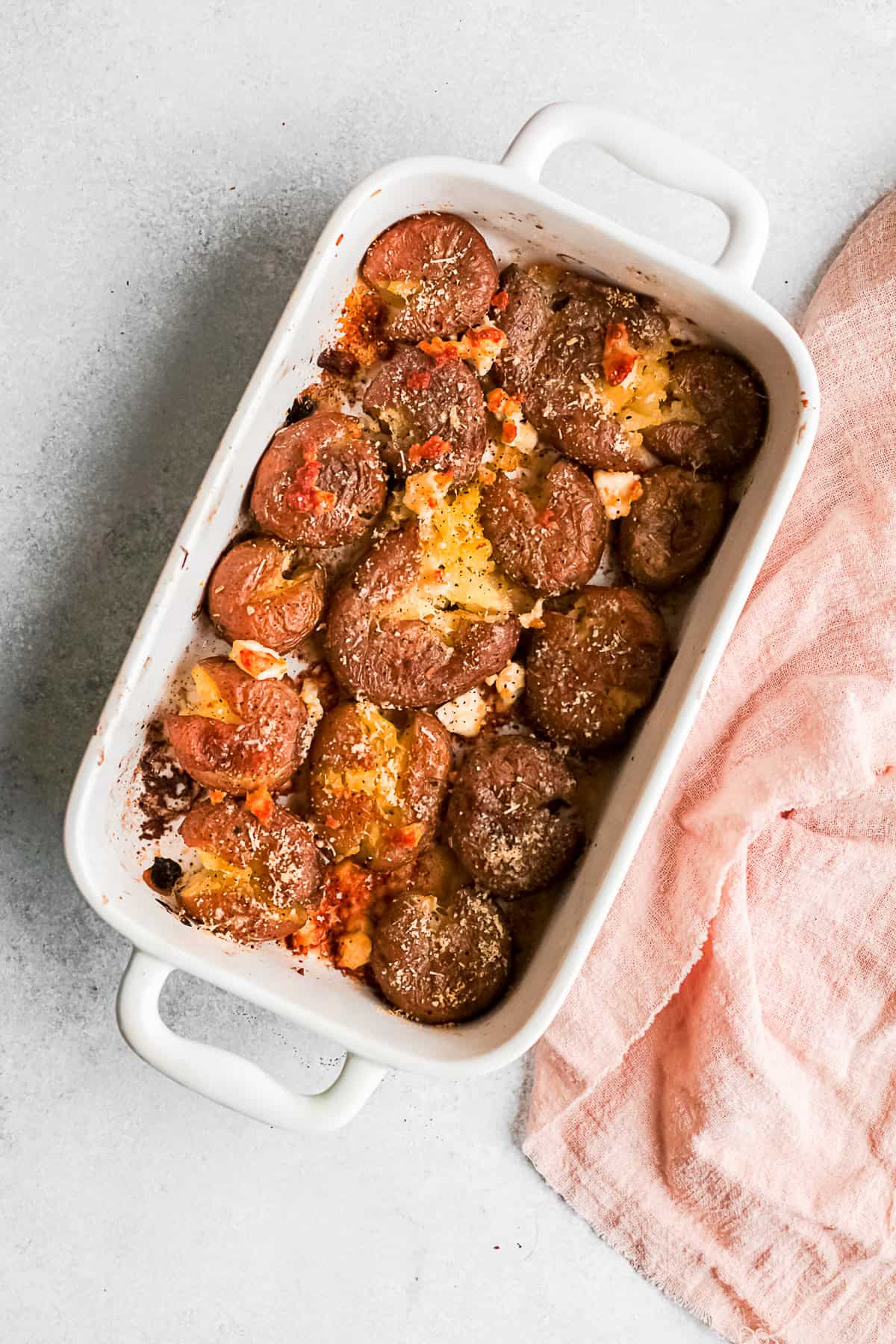 Cheesy Smashed Potatoes in a white baking dish. 