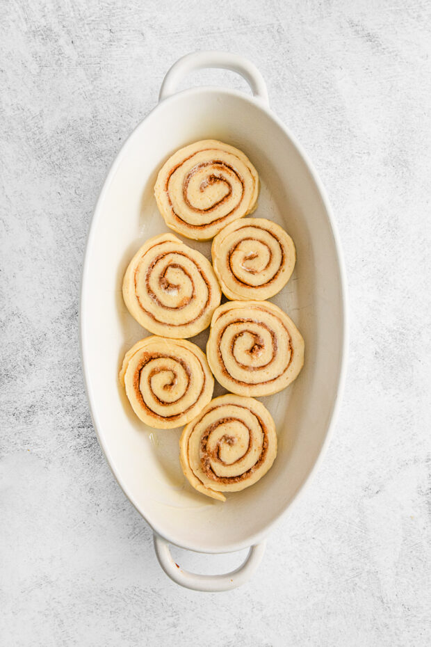 Unbaked cinnamon rolls in a baking dish.