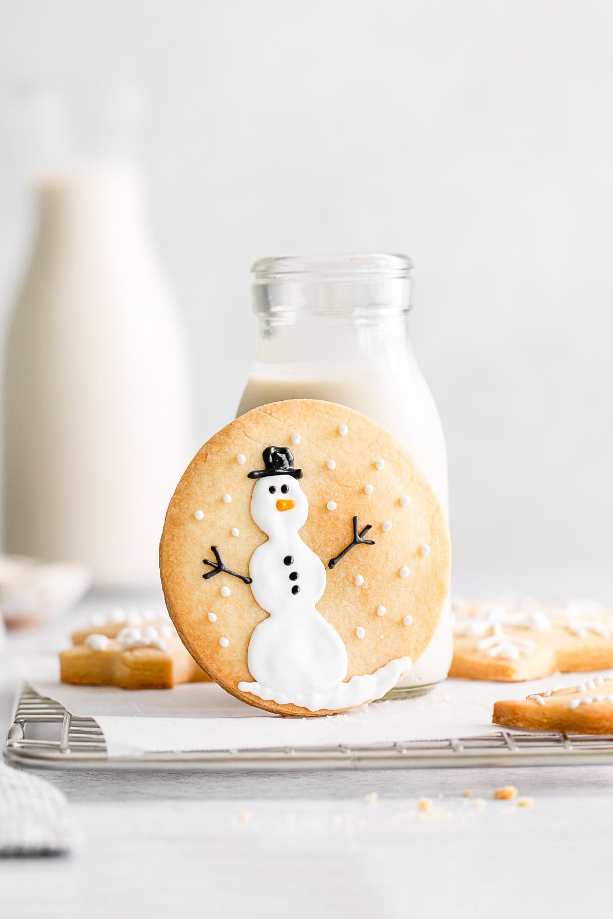 Peppermint Shortbread Cookie leaning up against a bottle of milk. 