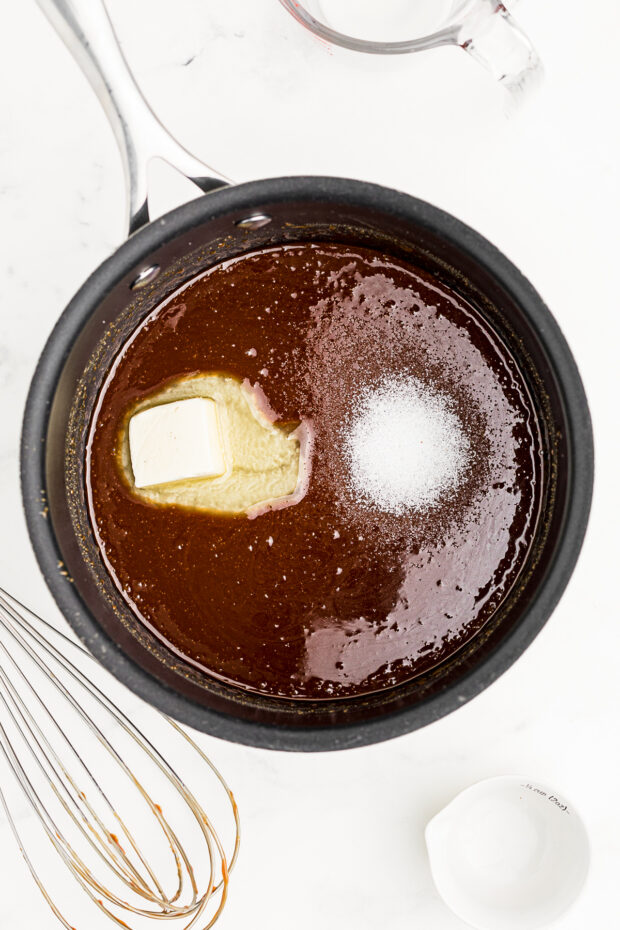 Salt and butter being added to caramel sauce.