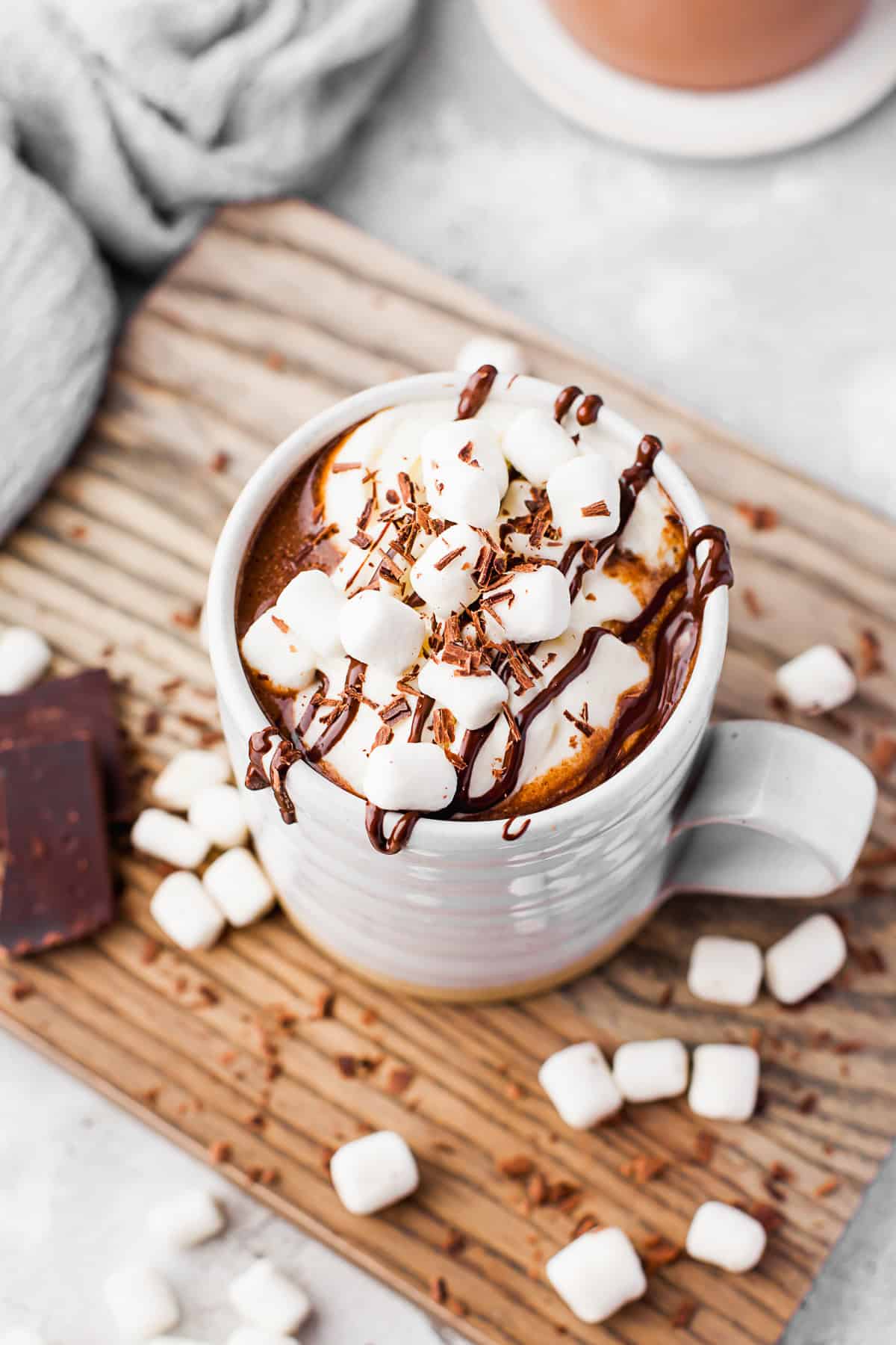 Slow Cooker Hot Chocolate topped with marshmallows and chocolate sauce.