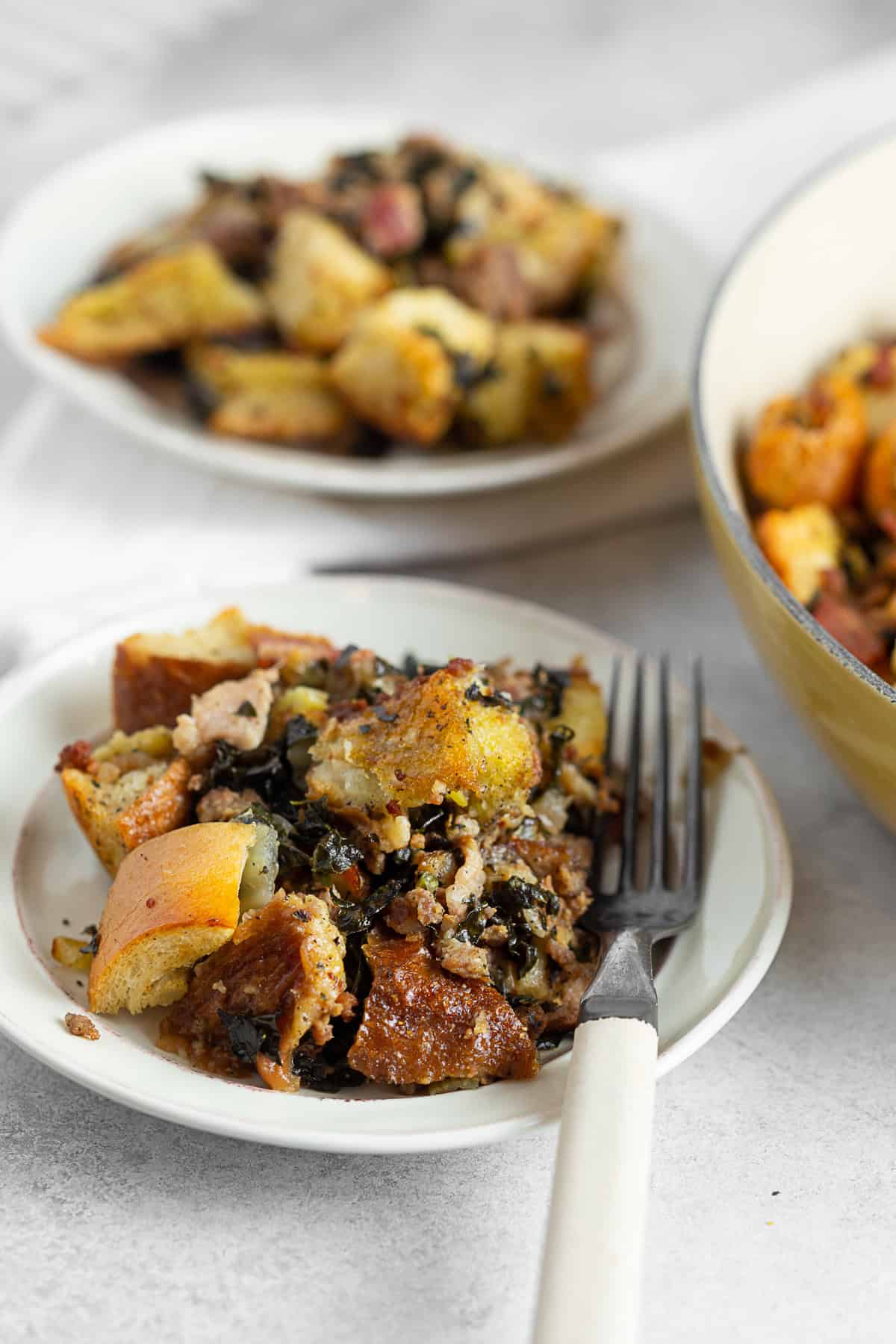 Sourdough Kale Bacon Sausage Stuffing on a plate with a fork. 