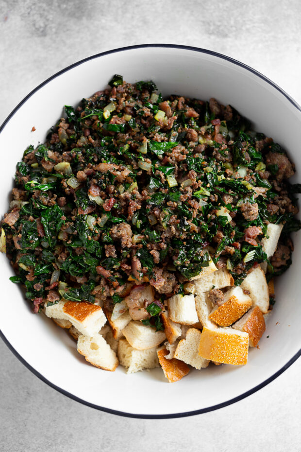 Browned sausage and kale with toasted bread in a bowl. 
