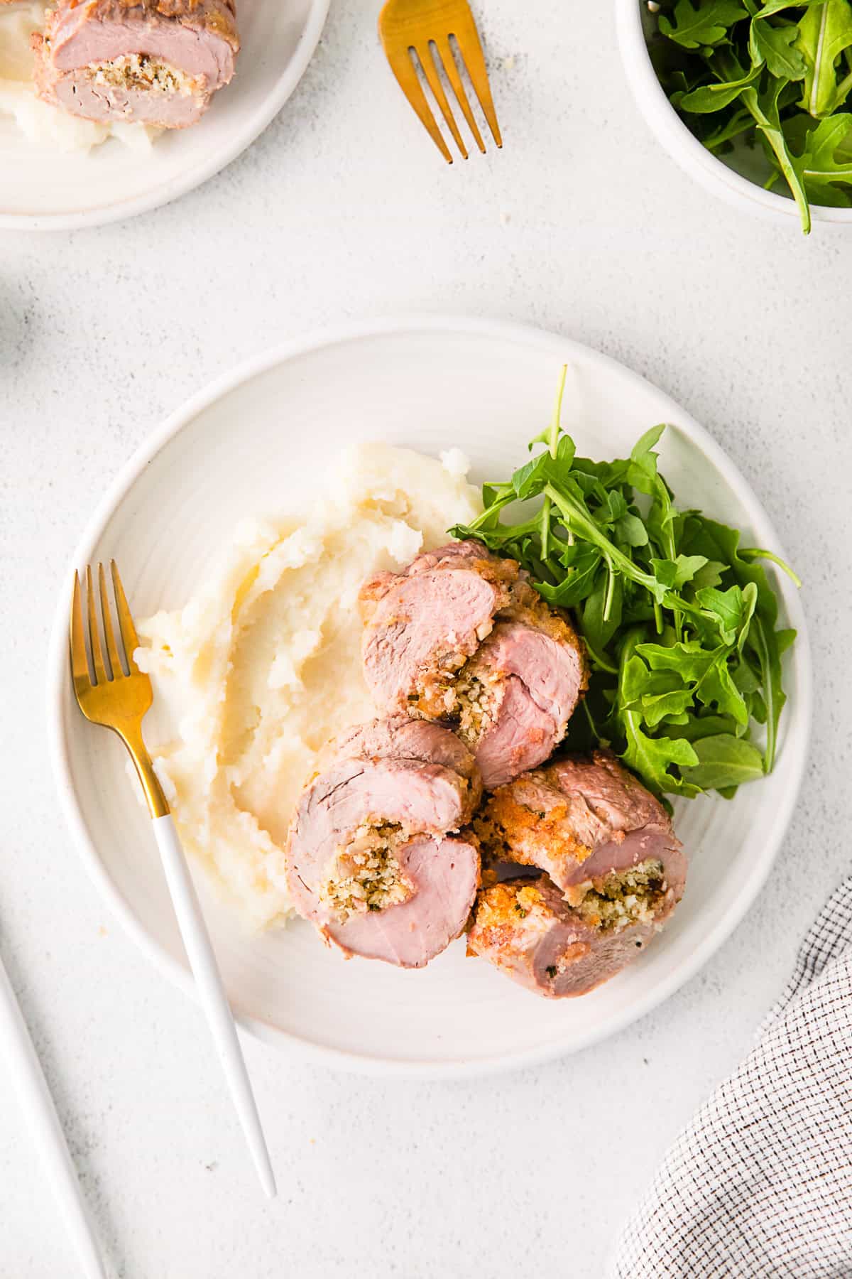 Stuffed Pork Tenderloin on a plate with mashed potatoes.