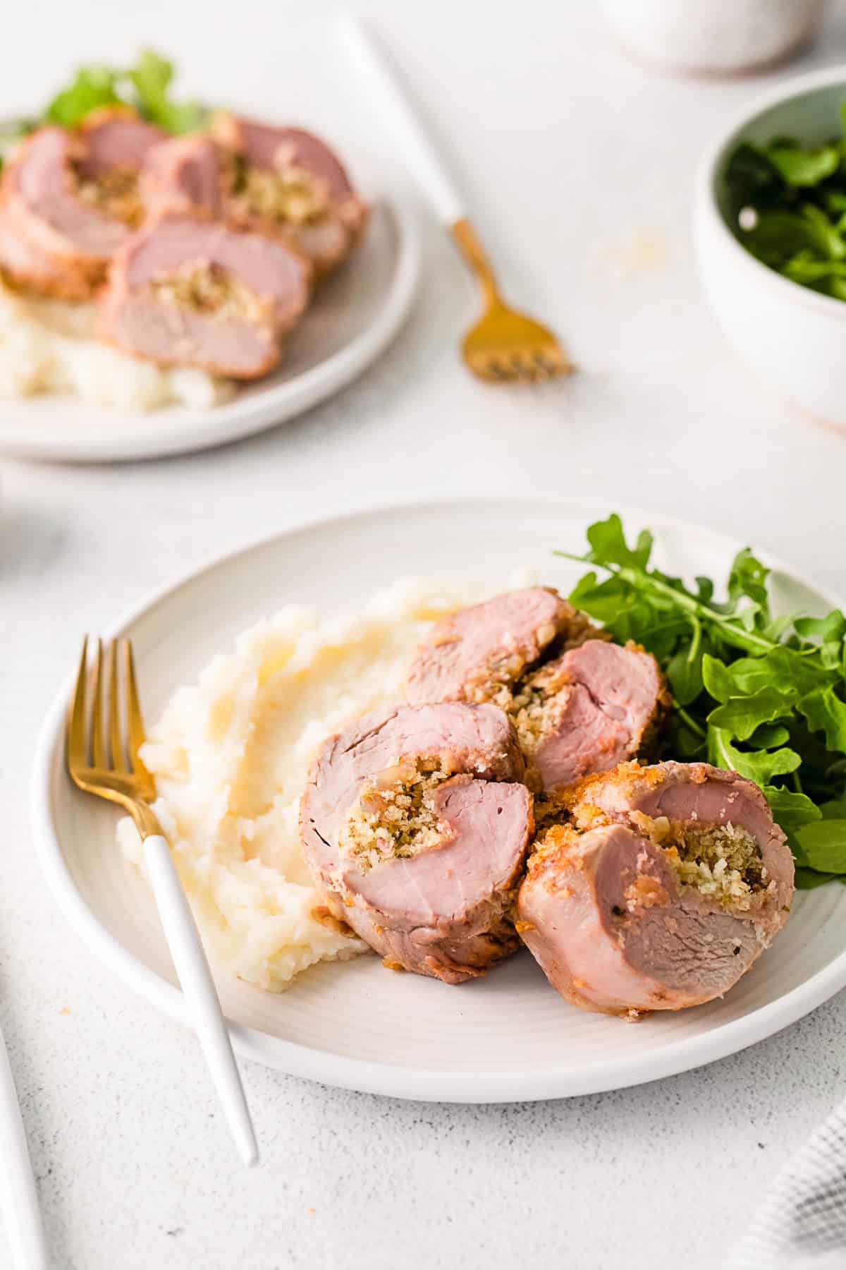 Stuffed Pork Tenderloin on a plate with a salad.
