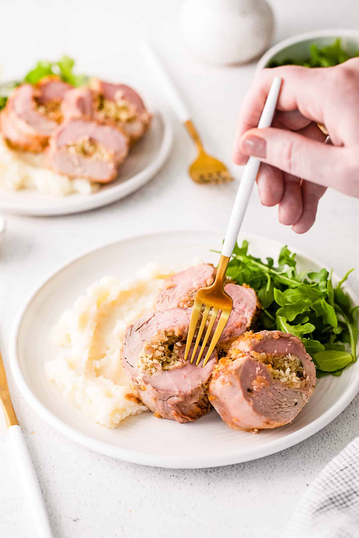 A fork stabbing a piece of Stuffed Pork Tenderloin.