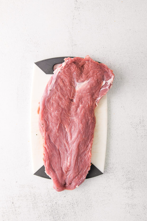 butterflied pork tenderloin on a cutting board.