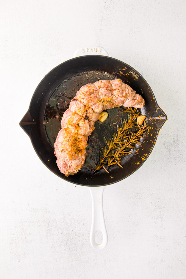 Stuffed Pork Tenderloin fully cooked in a skillet.
