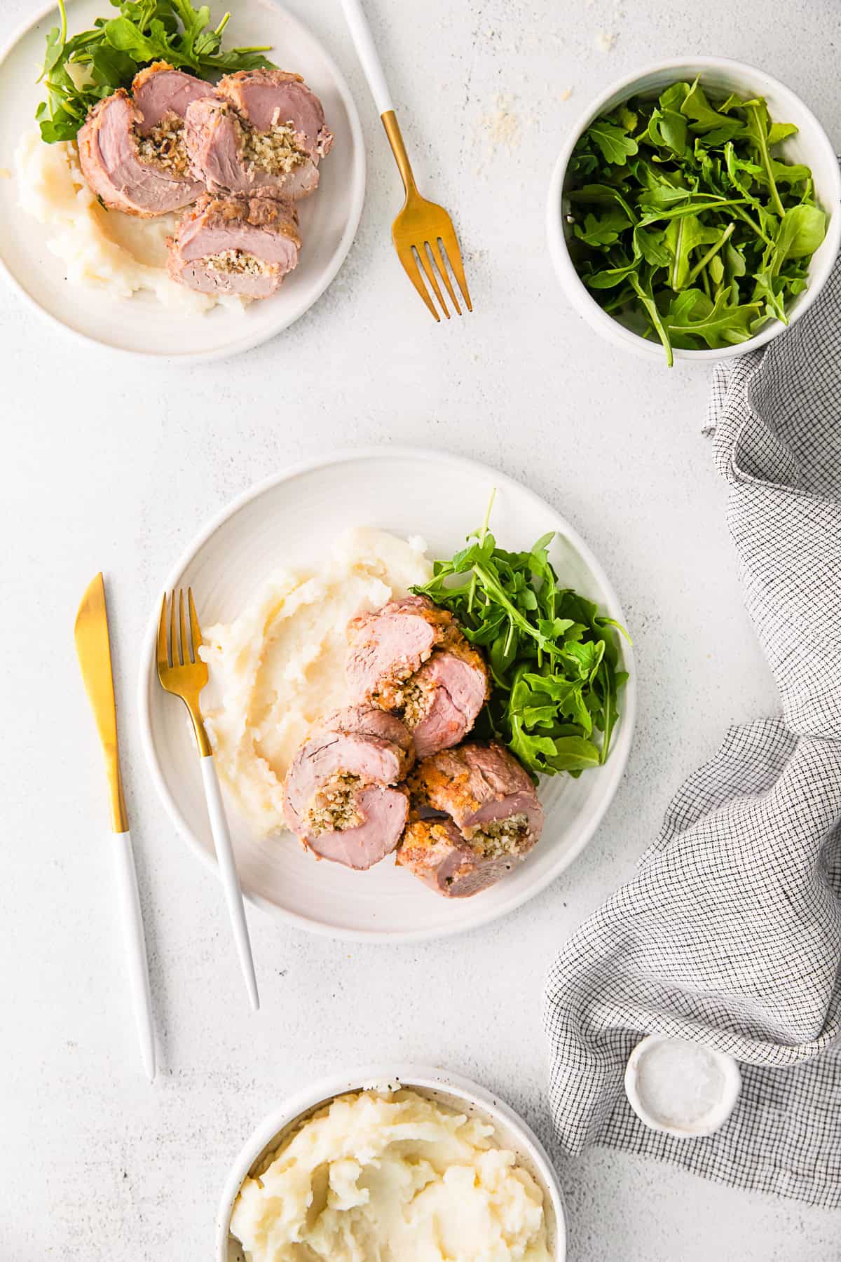 Stuffed Pork Tenderloin served with potatoes and salad.