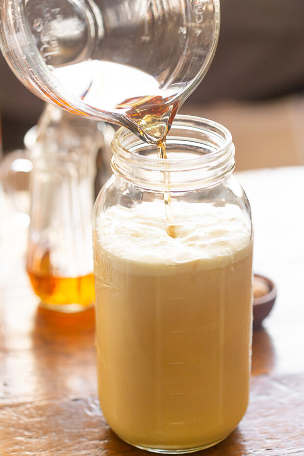 Bourbon being poured into aged eggnog.