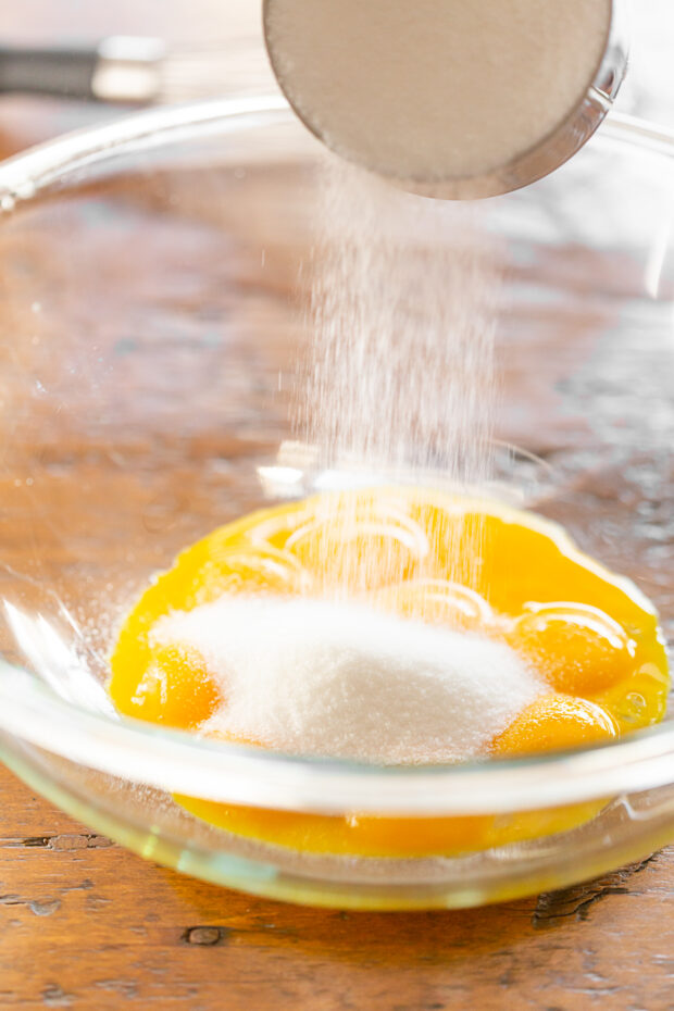 Egg yolks and sugar in a bowl.