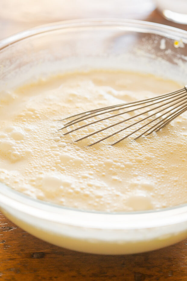 Fully whisked egg yolk and dairy mixture in a bowl.