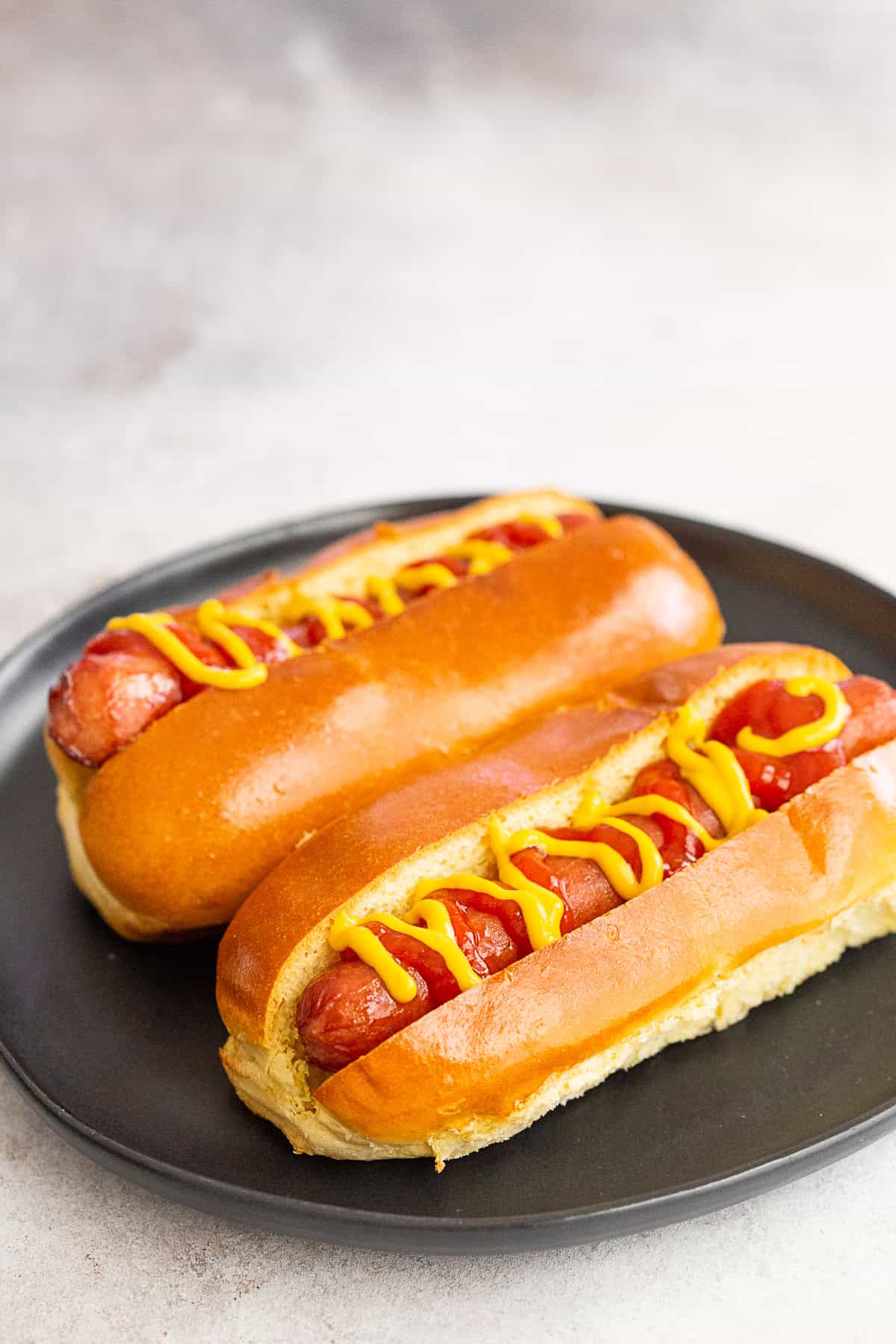 2 air fryer hot dogs on a plate.