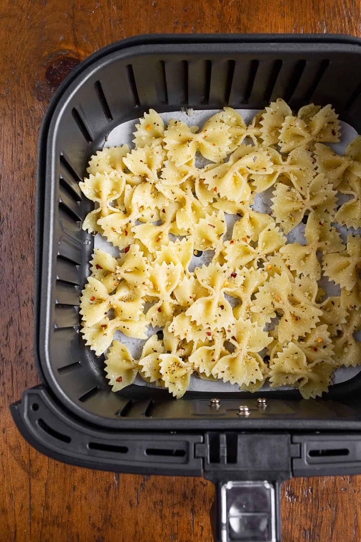 Pasta in an air fryer basket.