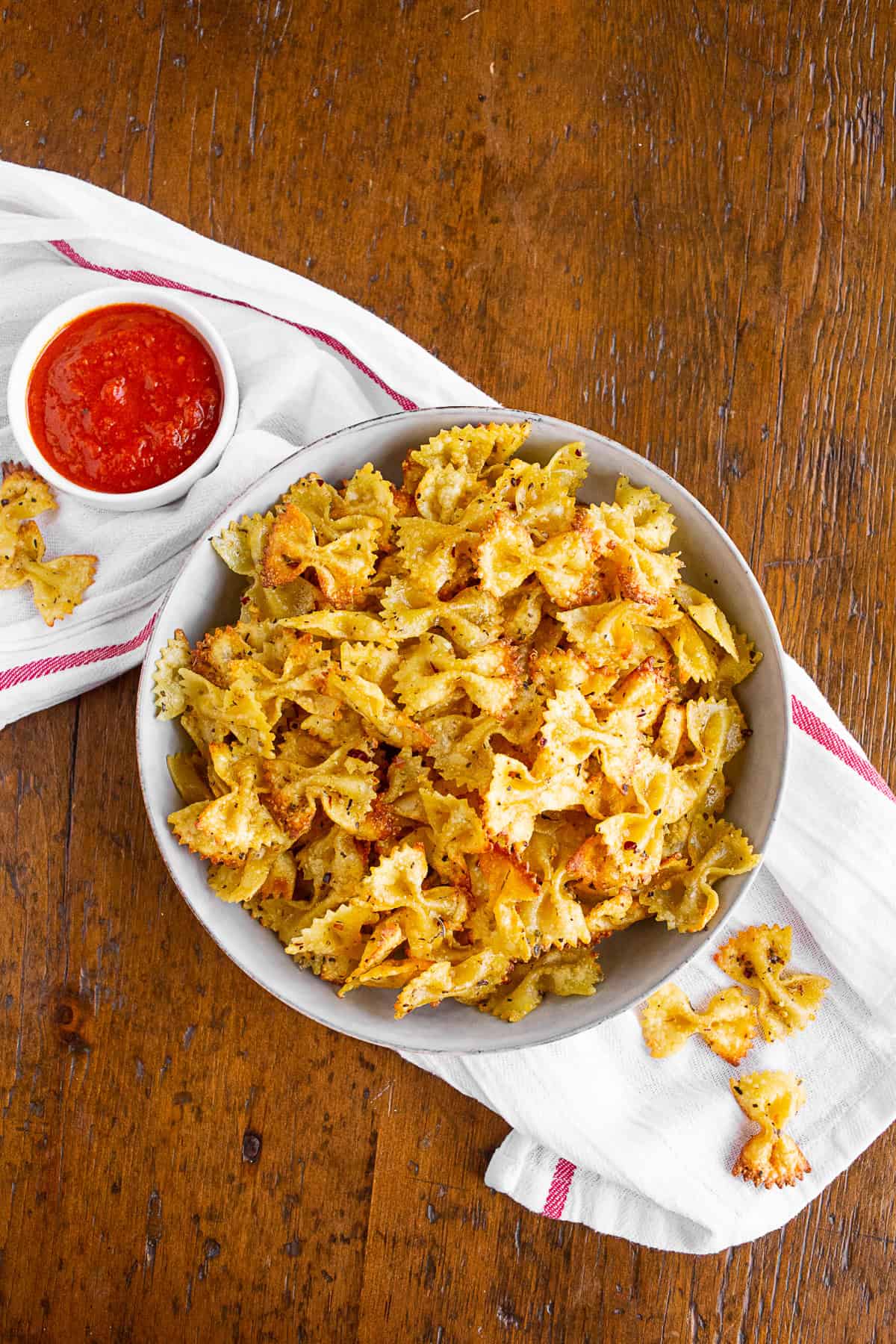 air fryer pasta chips in a bowl with marinara sauce.