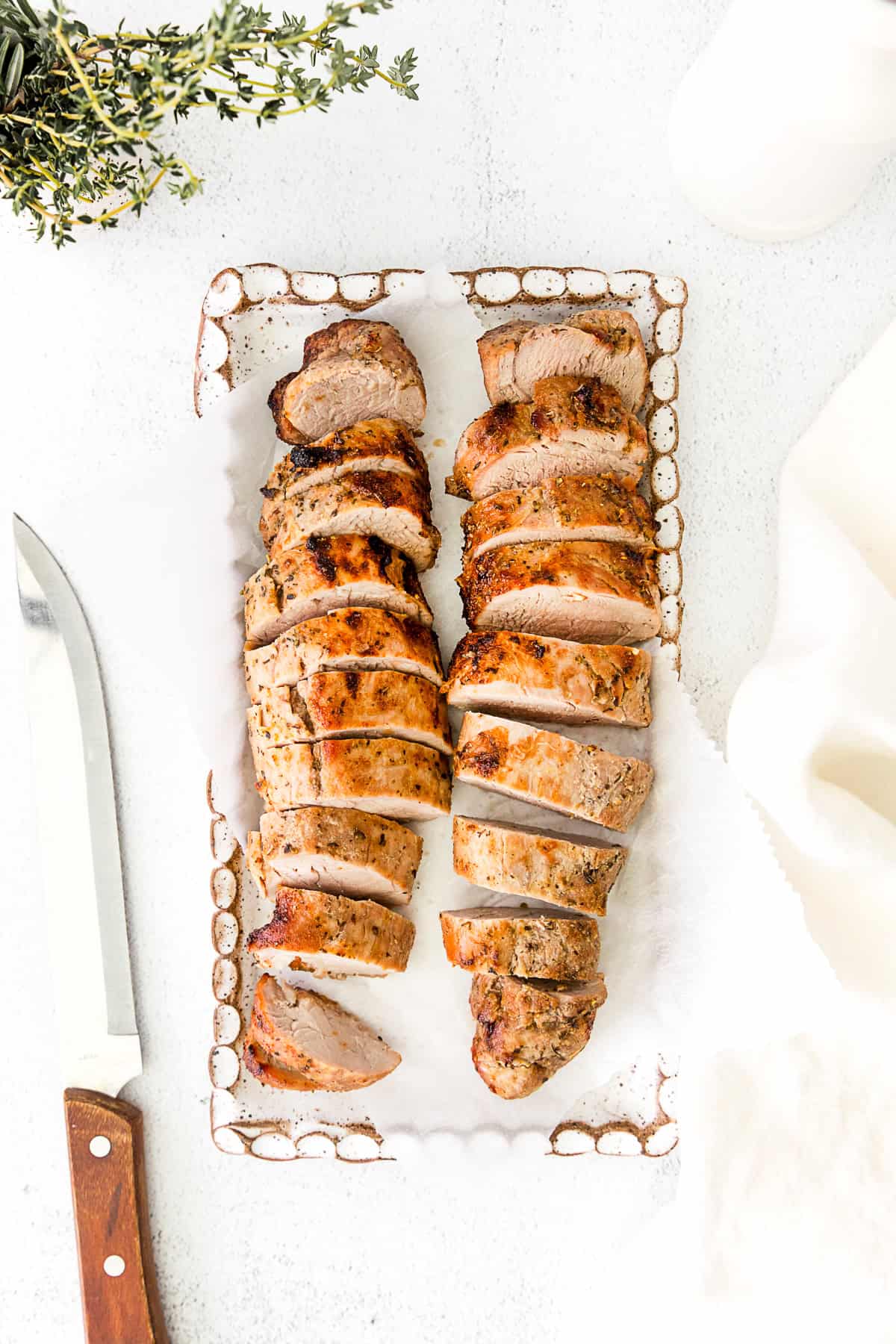 air fryer pork tenderloin on a white serving dish. 