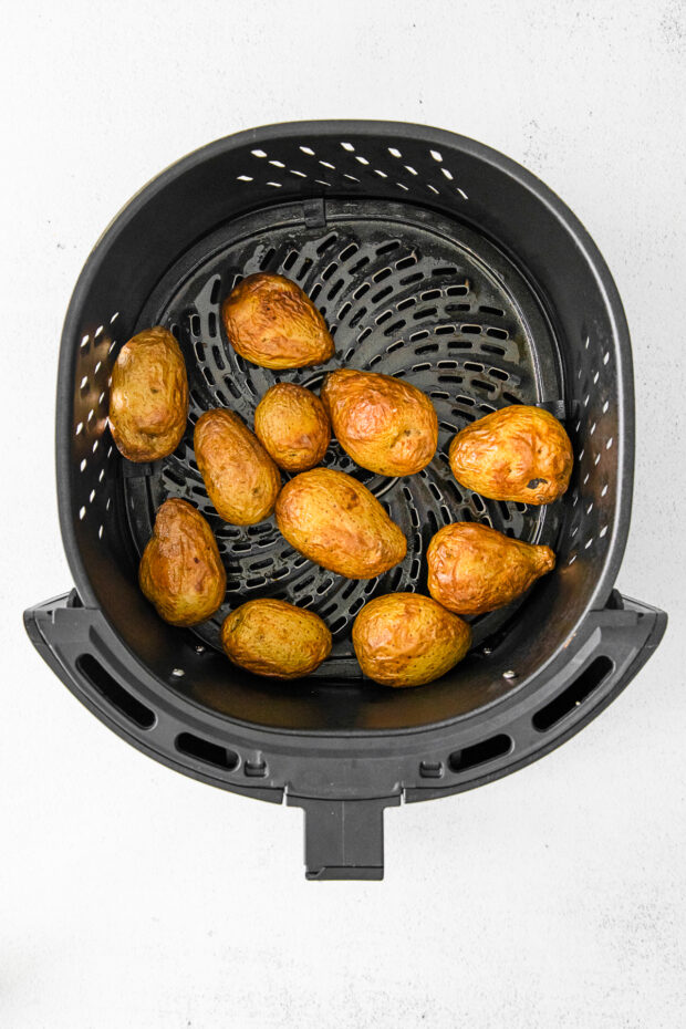 Roasted potatoes in an air fryer basket. 