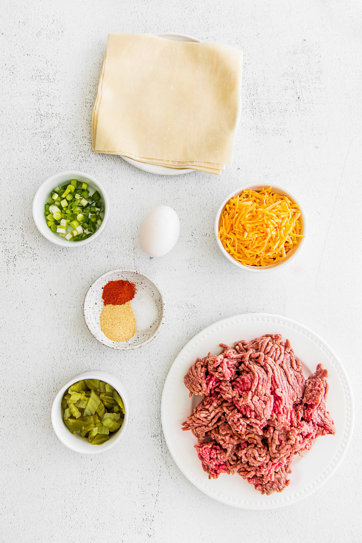 Air Fryer Cheeseburger Egg Roll ingredients on a table.