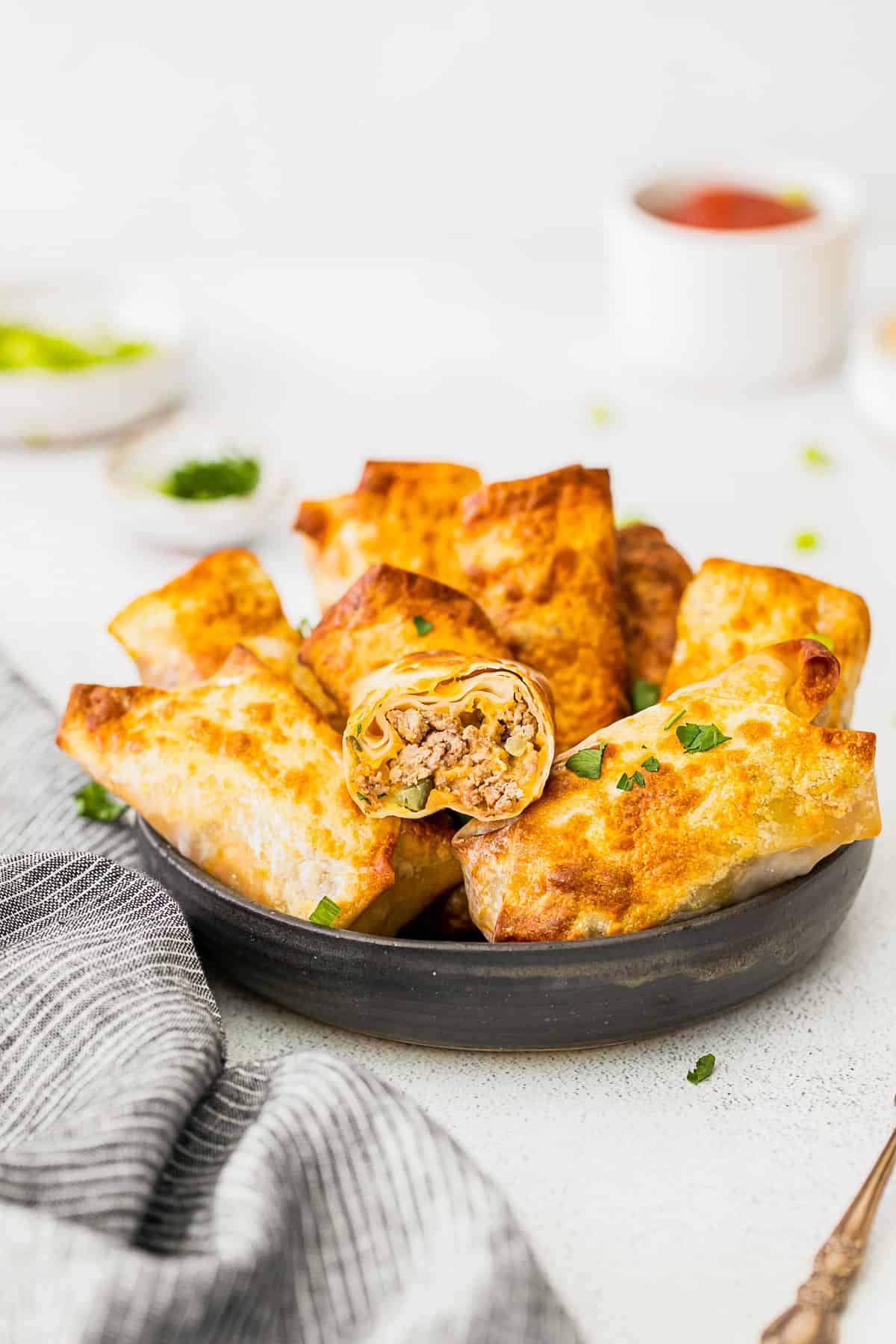 Air Fryer Cheeseburger Egg Rolls cut in half to show filling.
