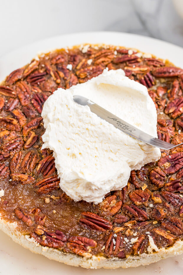 Pecan pie with frosting on top of it. 