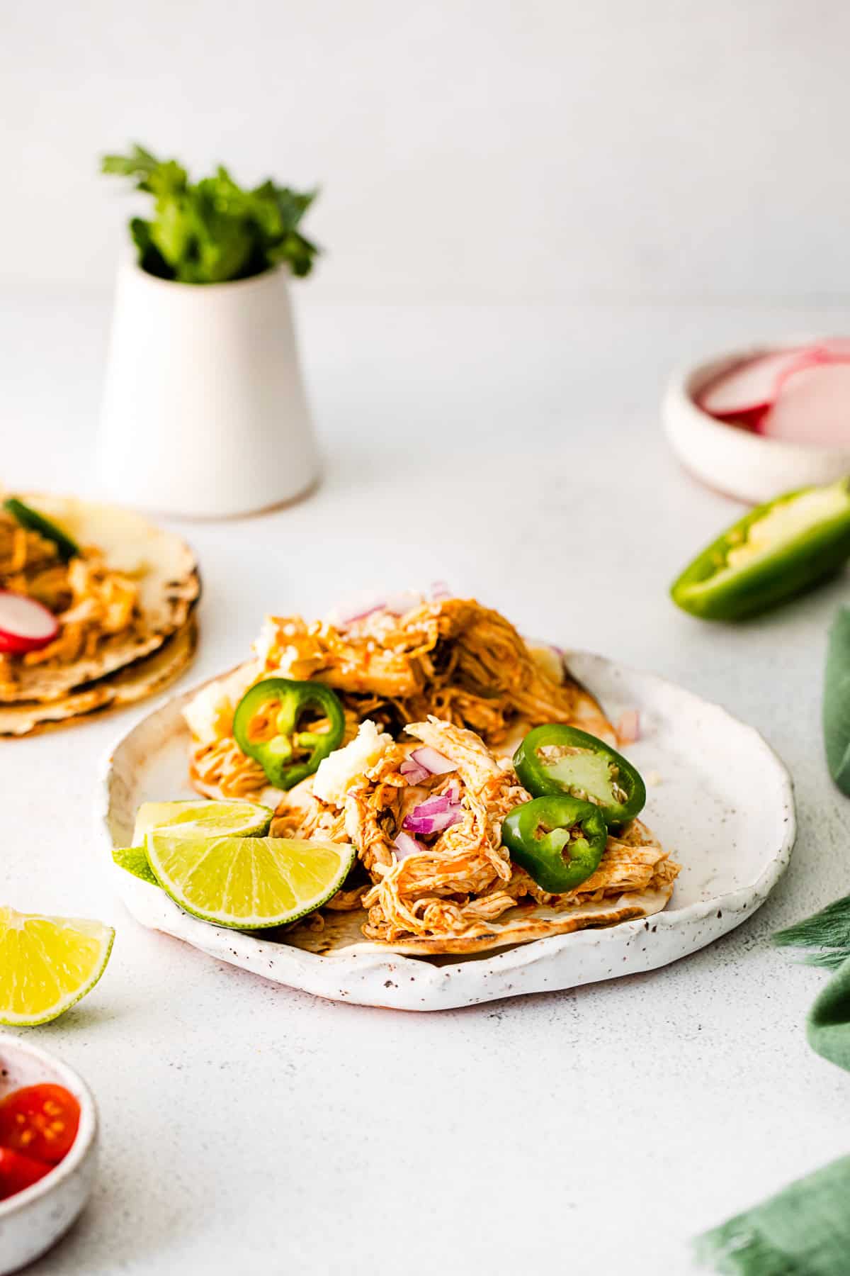 Instant Pot Chicken Tacos topped with cheese and peppers. 