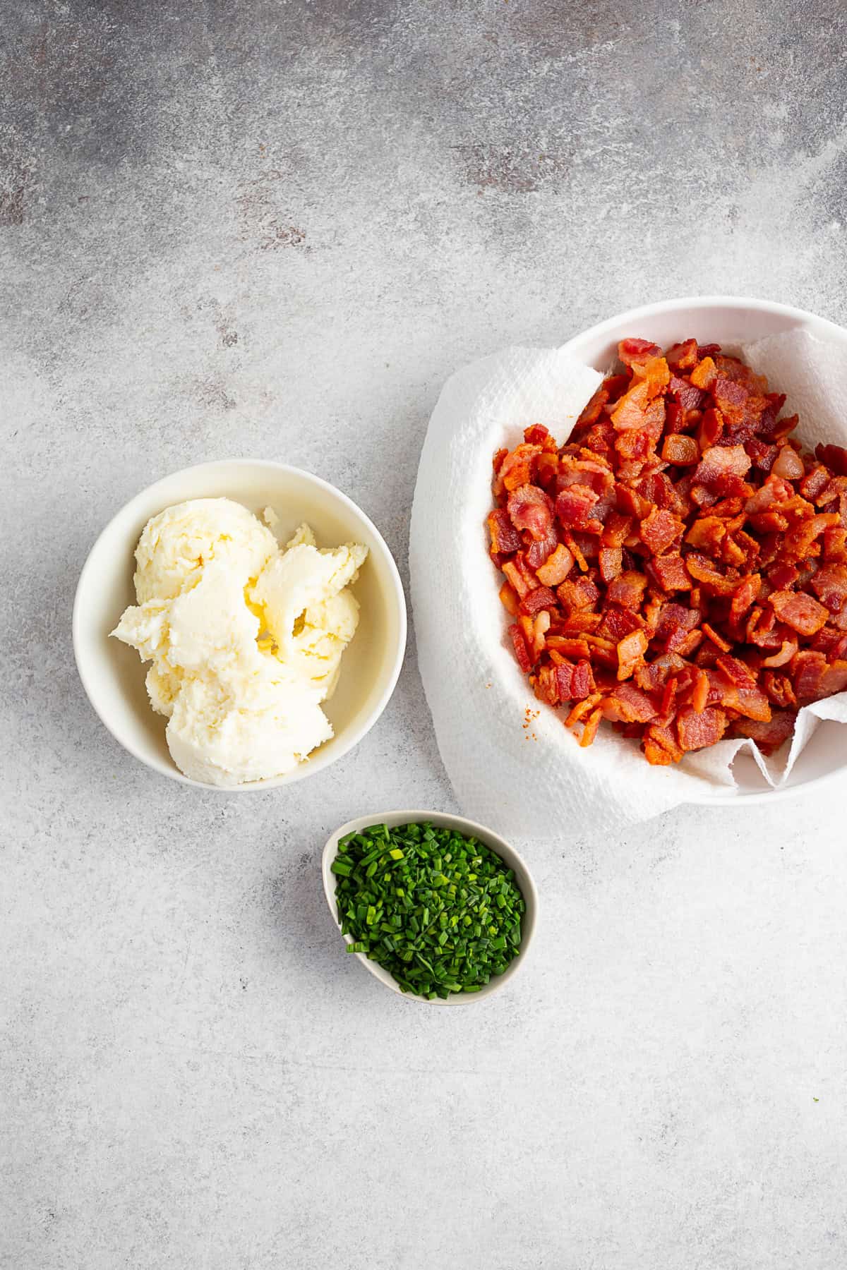 Bacon, chives, and cheese on a table. 