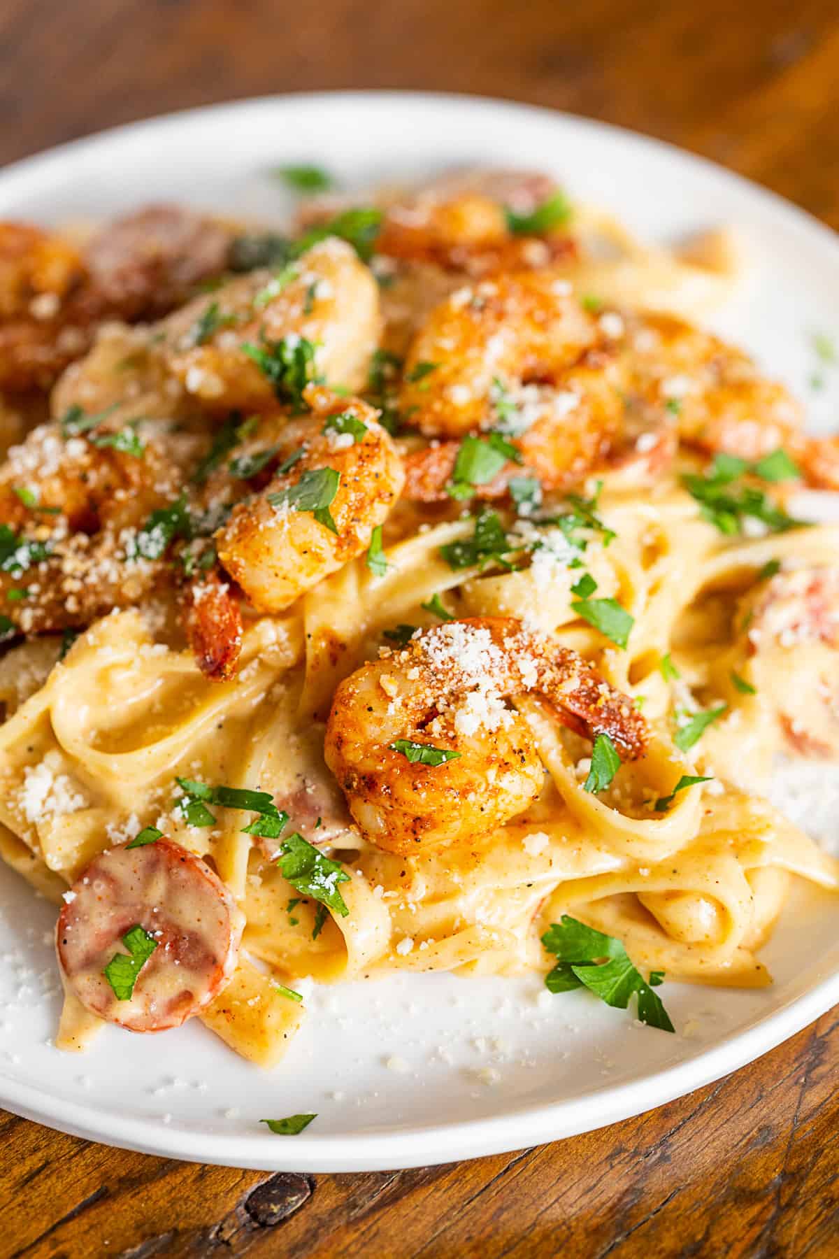cajun shrimp fettuccine alfredo on a plate topped with parmesan cheese.